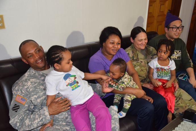 The Enyioko family visit with 1st Sgt. Melanie Scott and Master Sgt. Michael Henry, senior noncommissioned officers assigned to Headquarters. PHOTO: Kcrg.com