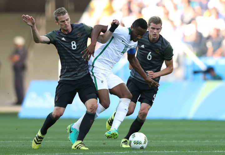 Mikel Obi being tackled by German defence