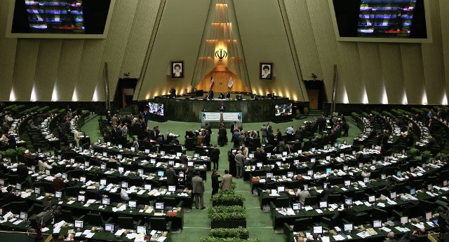 U.S flag burnt by Iranian hardliners , copy of nuclear deal in parliament